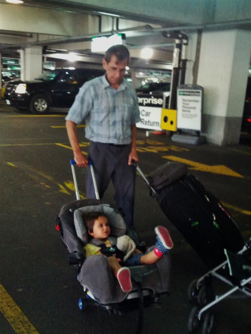 Dad pushing a bag and his Grand daughter at the Dublin Airport Enterprise pick up