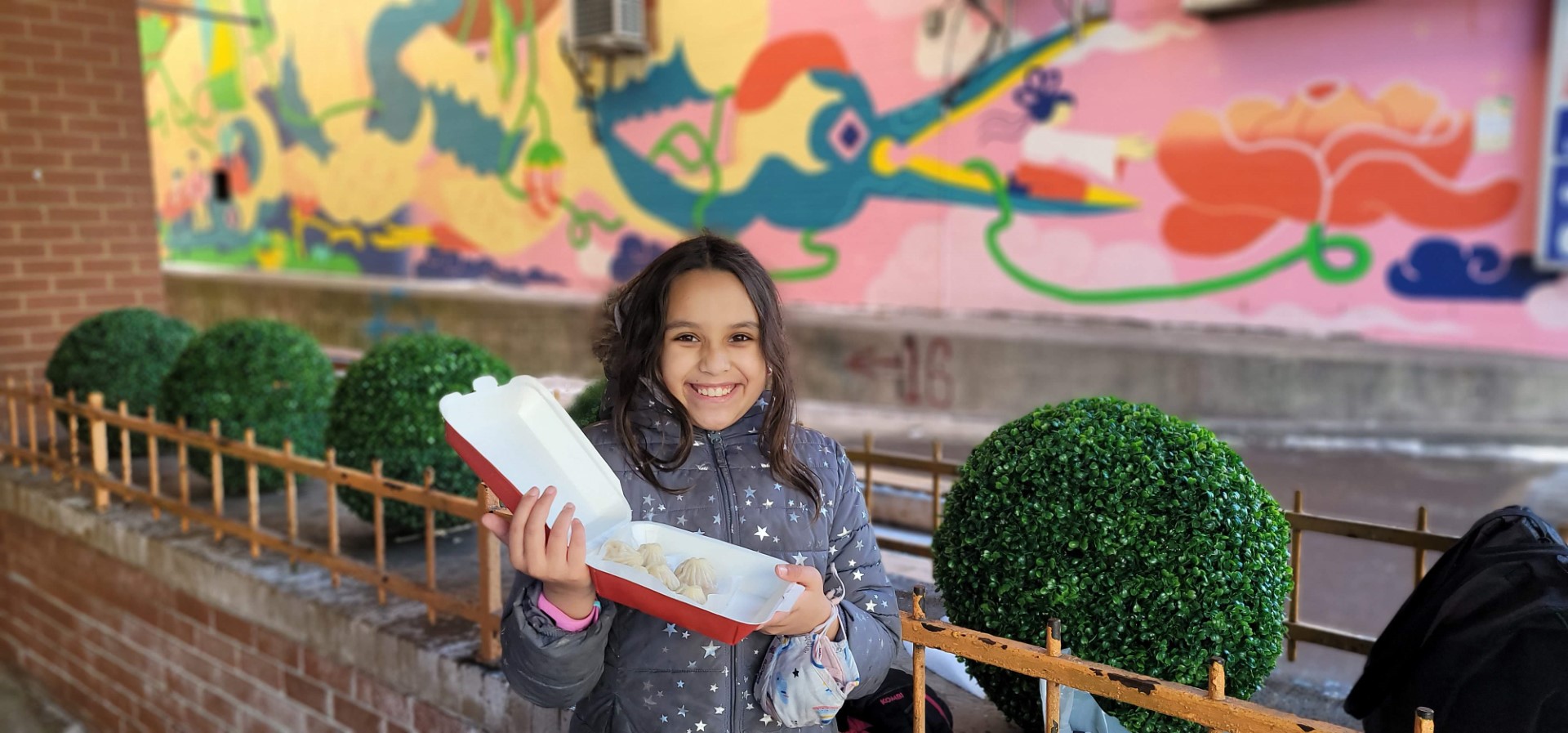 child holding box of dumplings in Chinatown Toronto