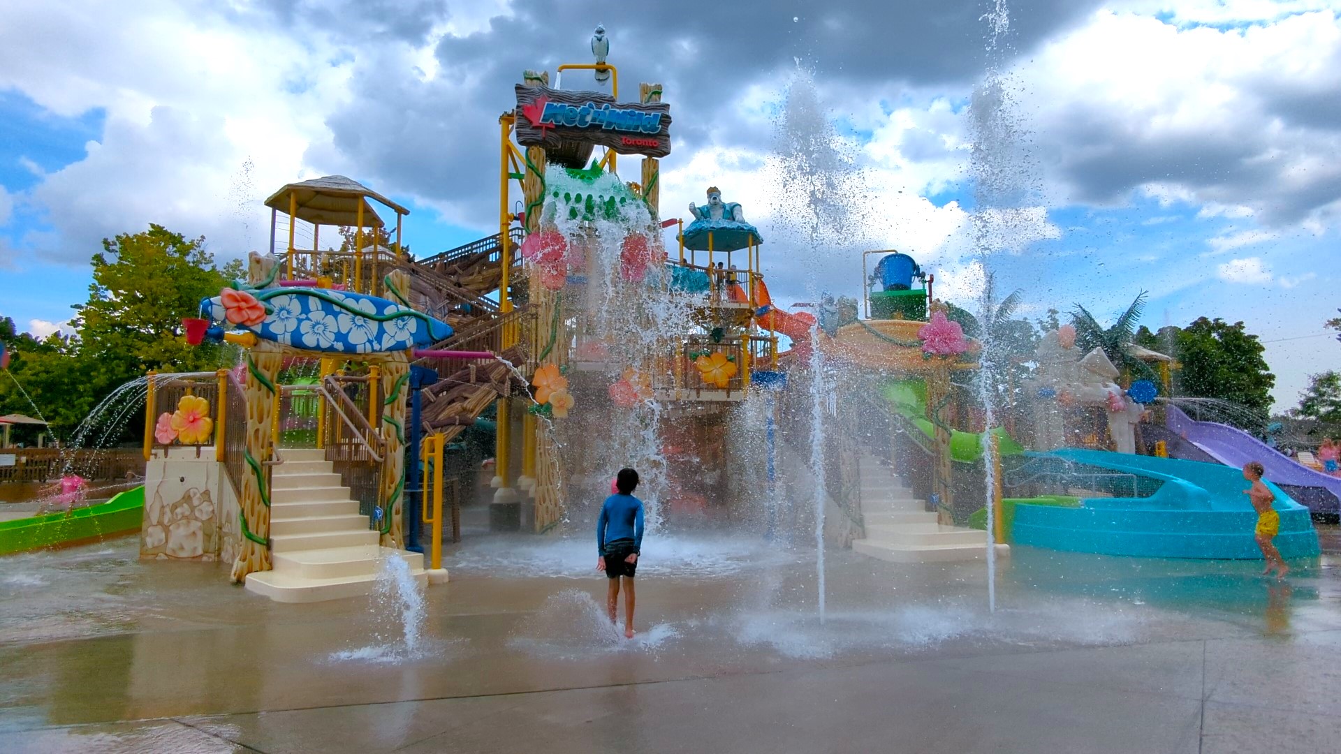 kid standing in front of wet n wild Toronto slide