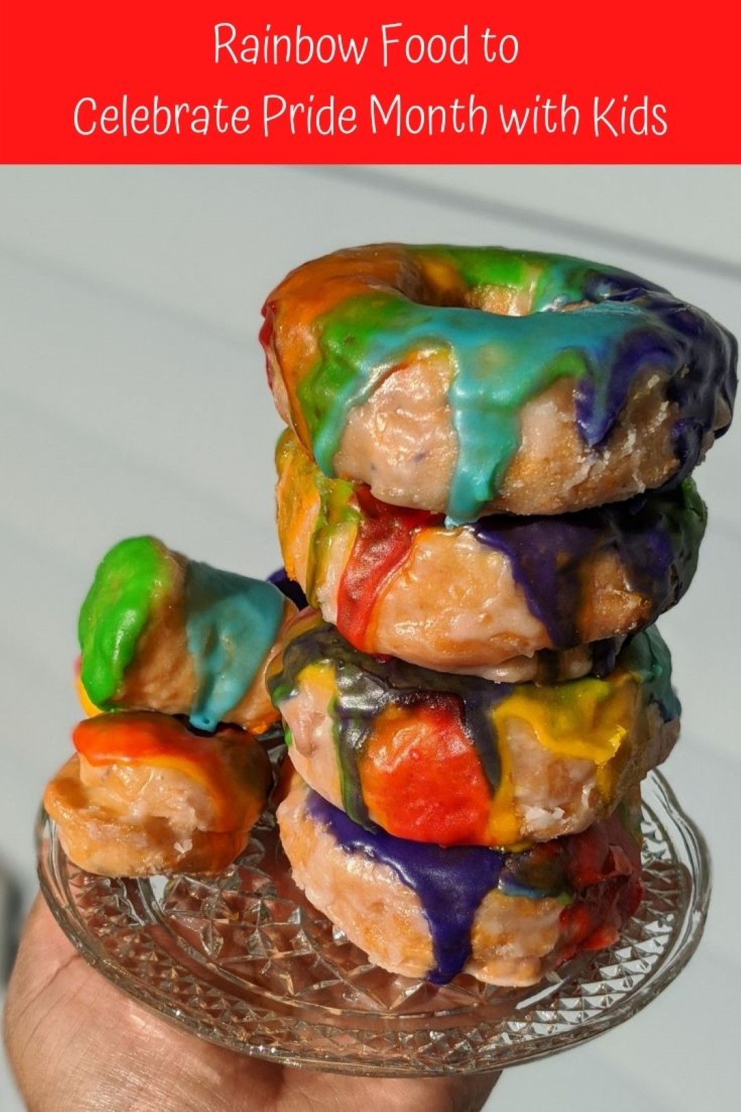 rainbow donuts on plate with hand holding it