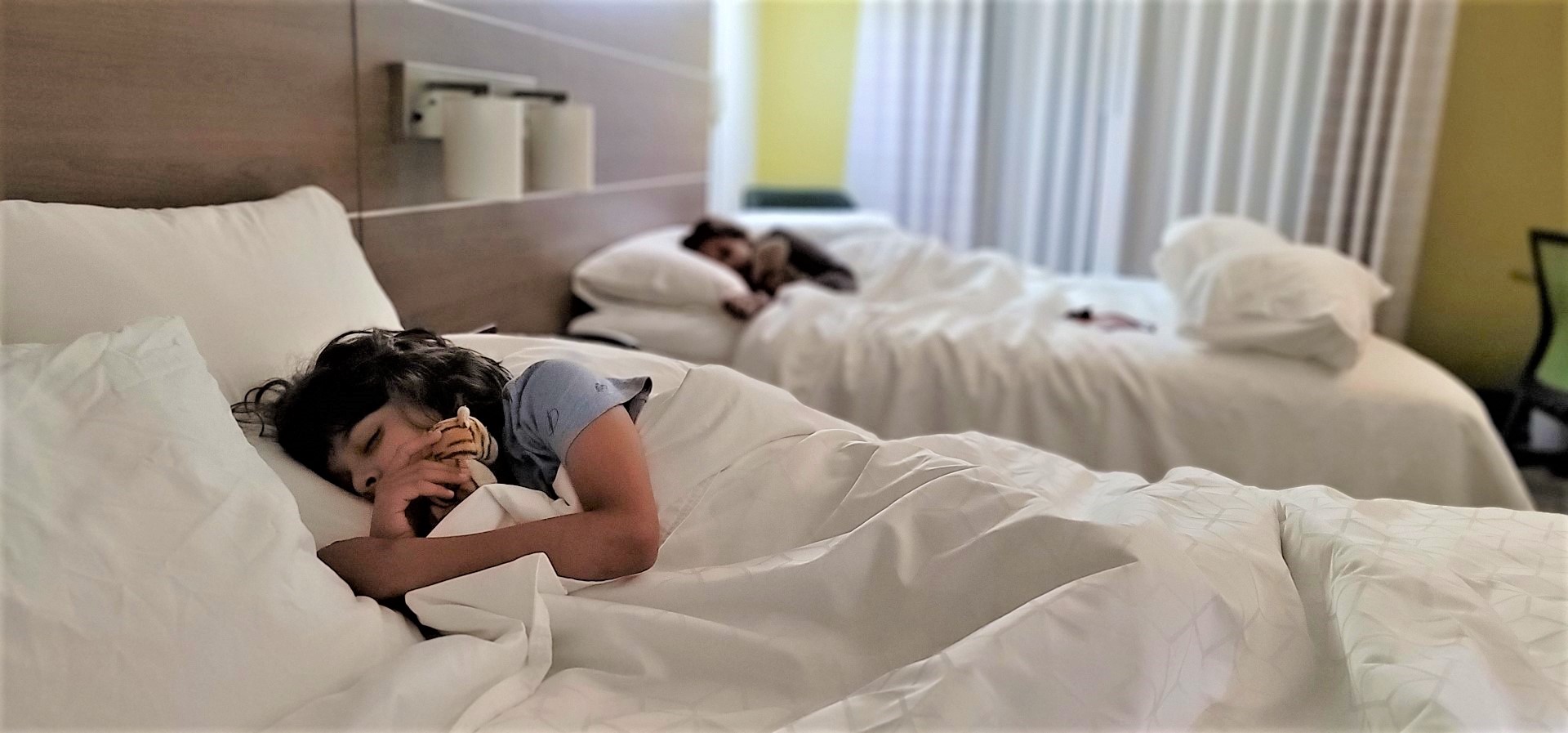 children sleeping in hotel bed