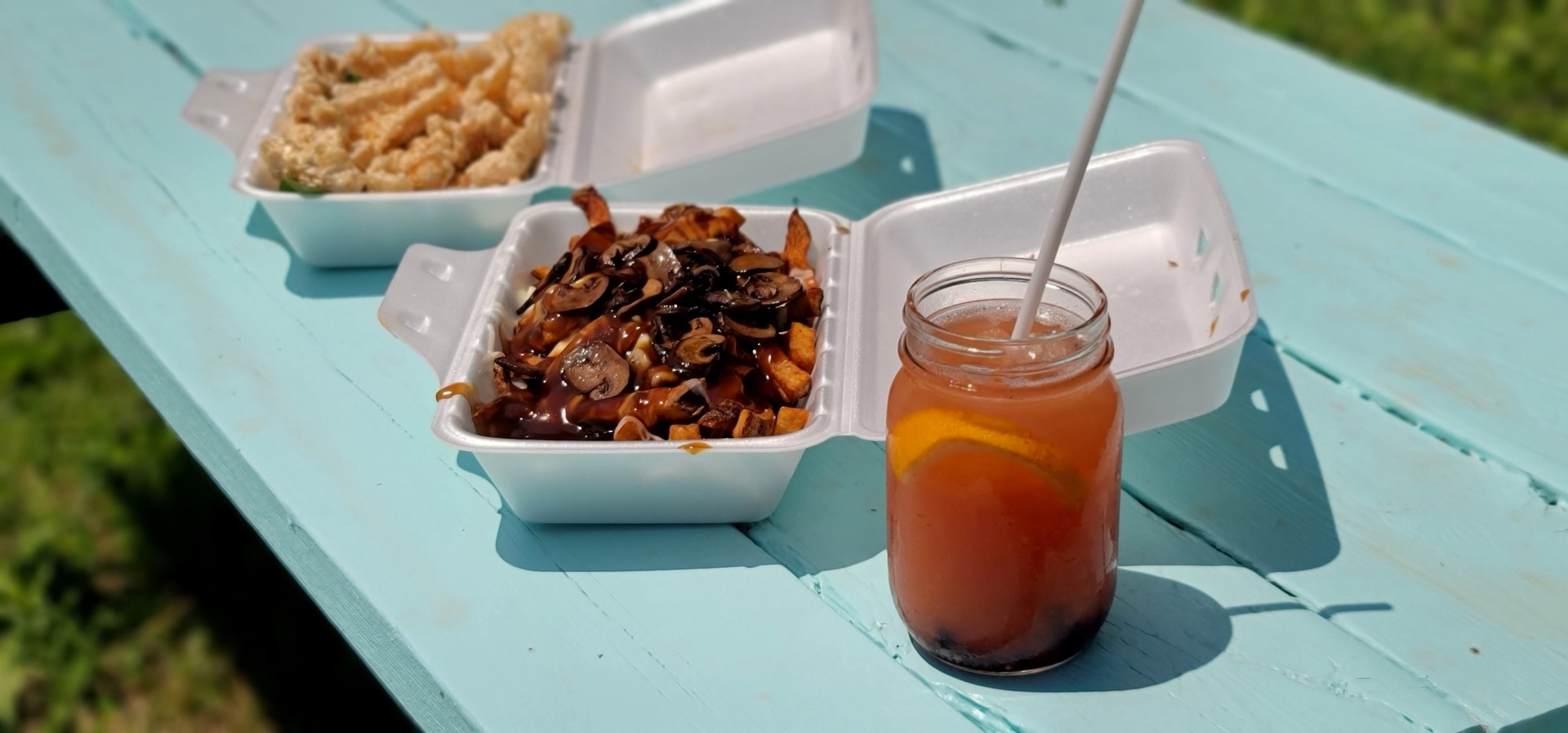 red sangria and poutine on blue picnic bench