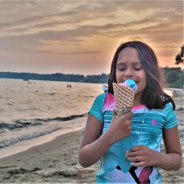 sunset with girl eating blue ice cream