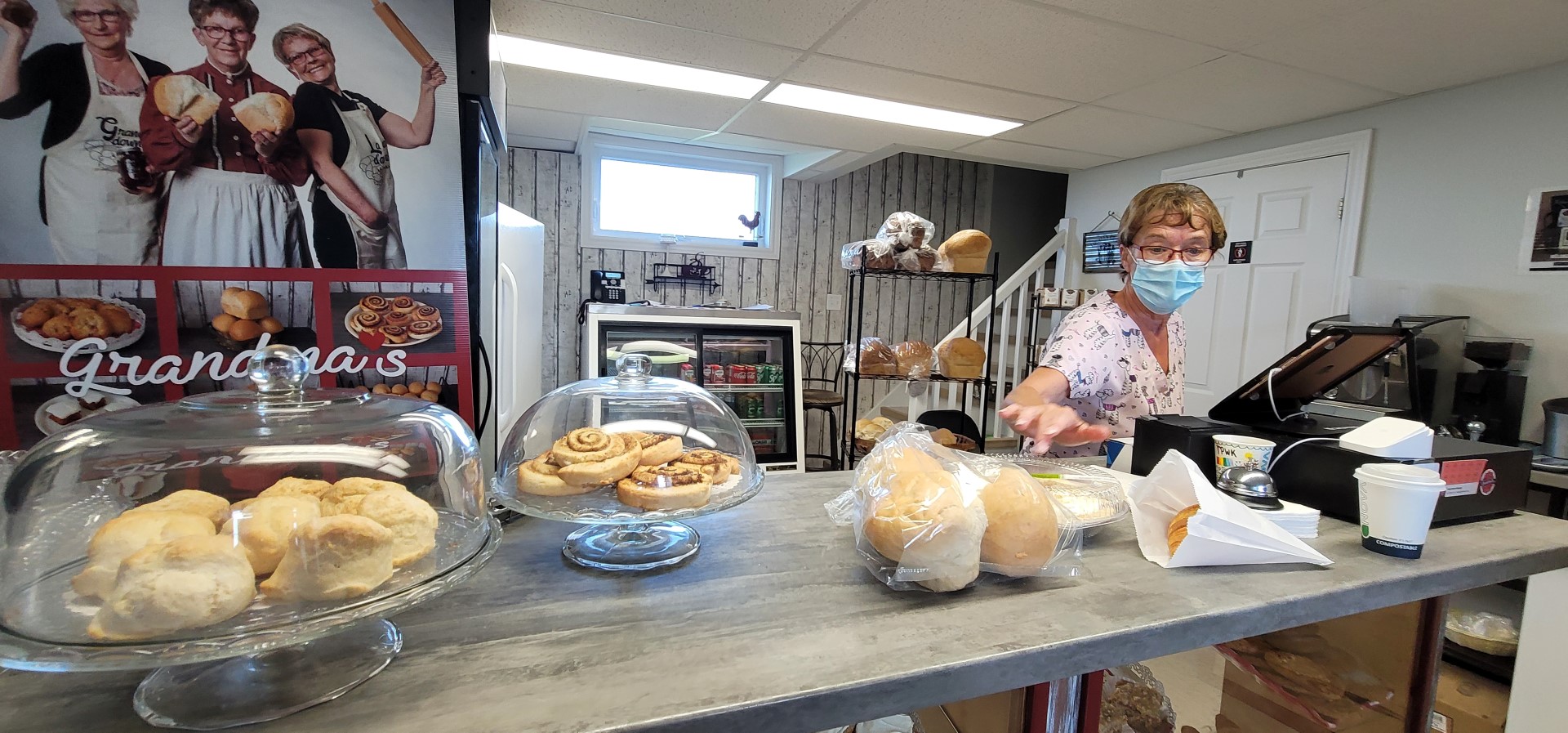 Inside of Bakery with owner reaching for baked goods