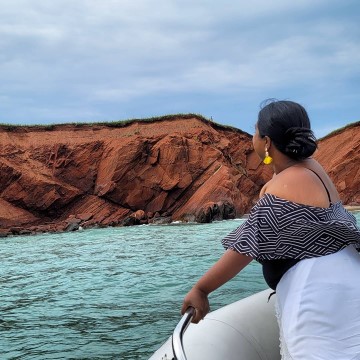 lady looking at red cliffs on Magdalen Islands
