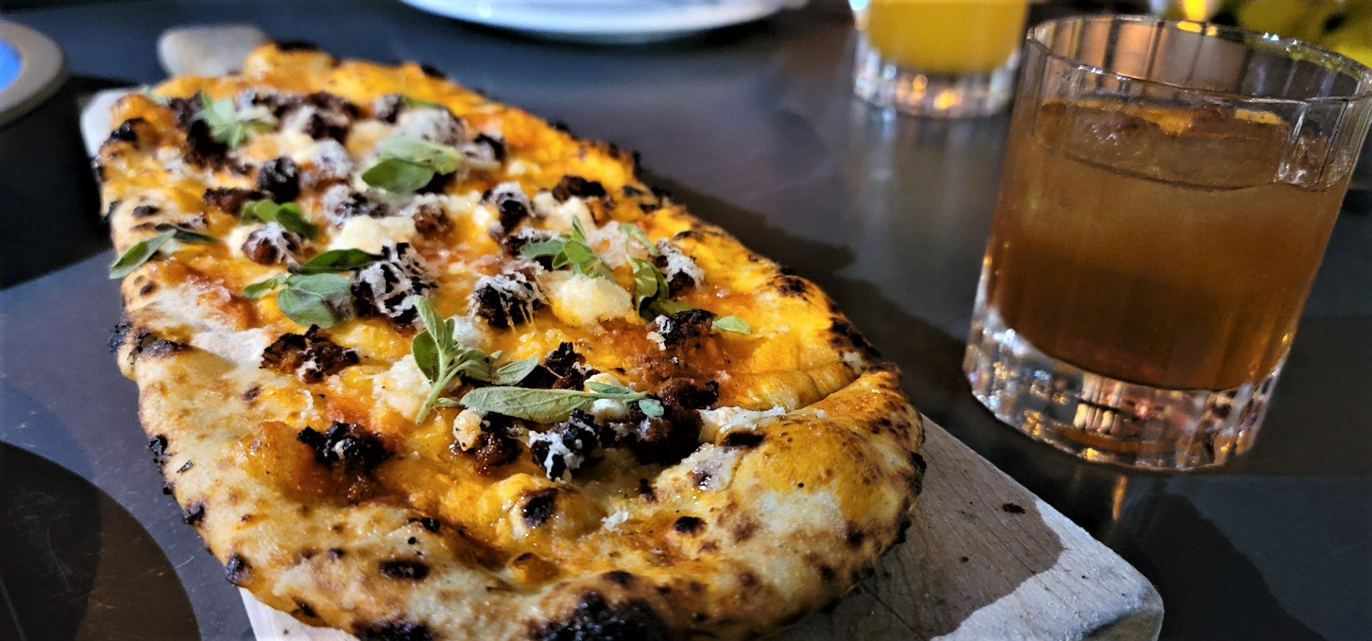'nudja flatbread with cheese drizzled and cocktail