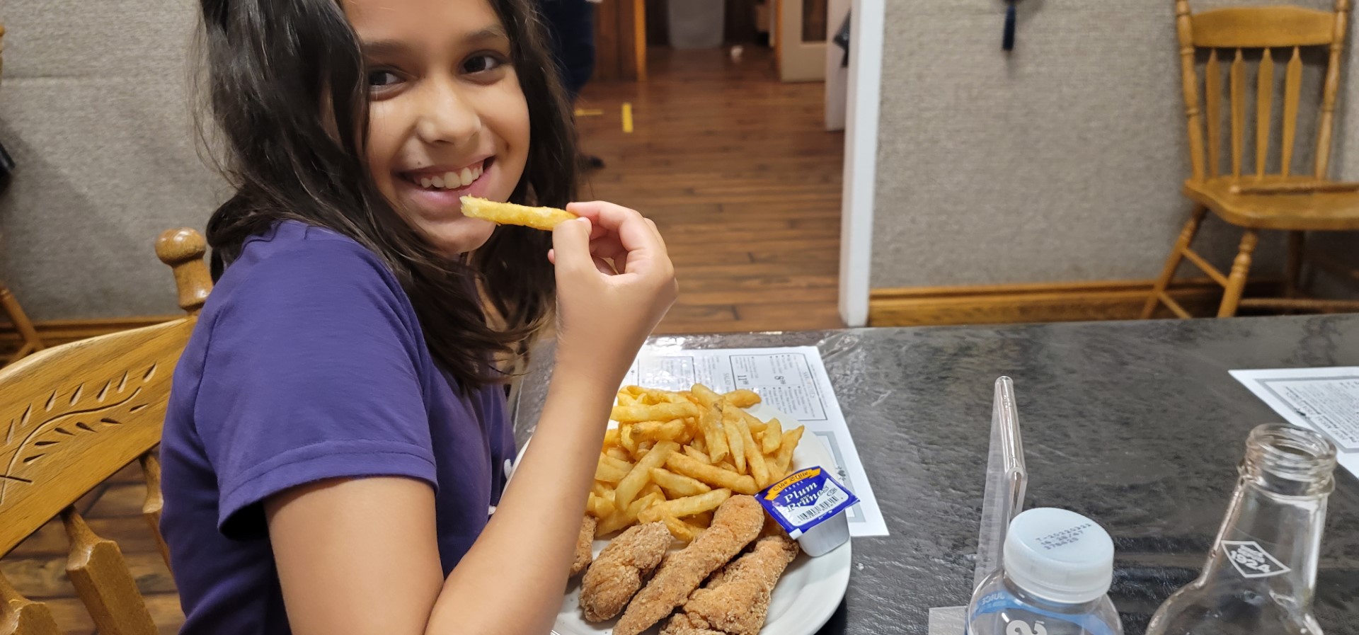 child eating fries smiling at camera