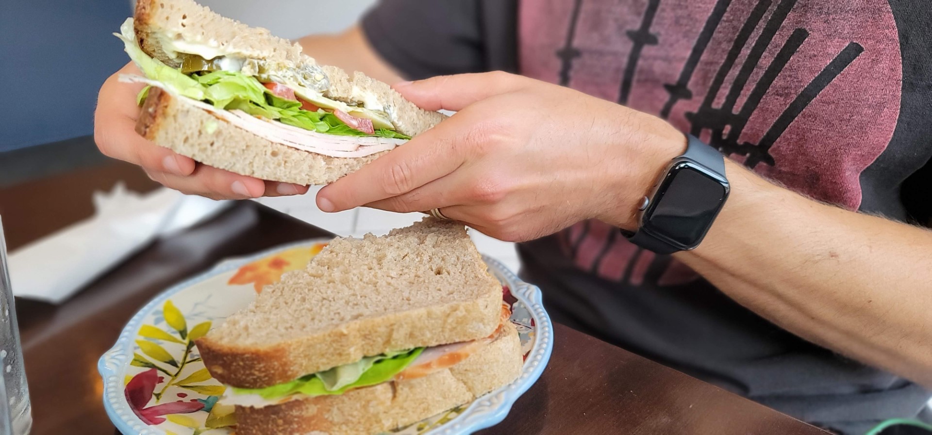 hands holding freshly made sandwich