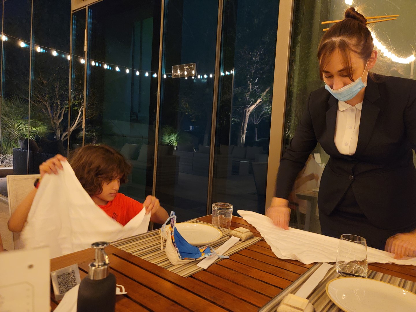 server and child folding napkin