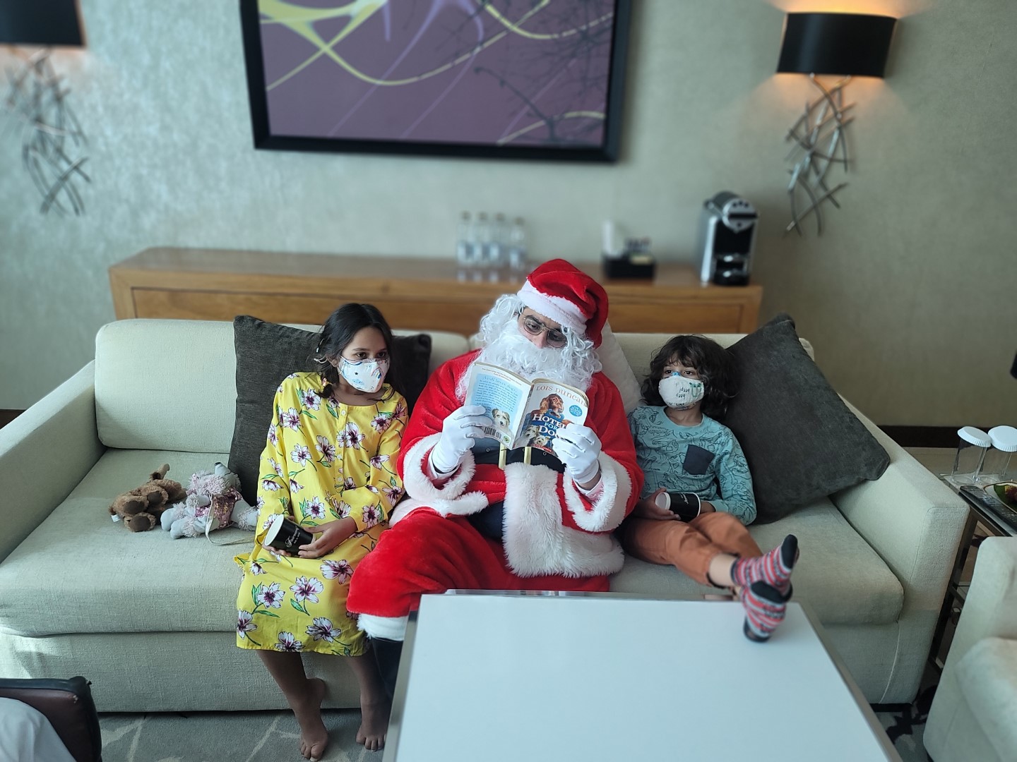 Santa reading to kids in Abu Dhabi seated on a couch