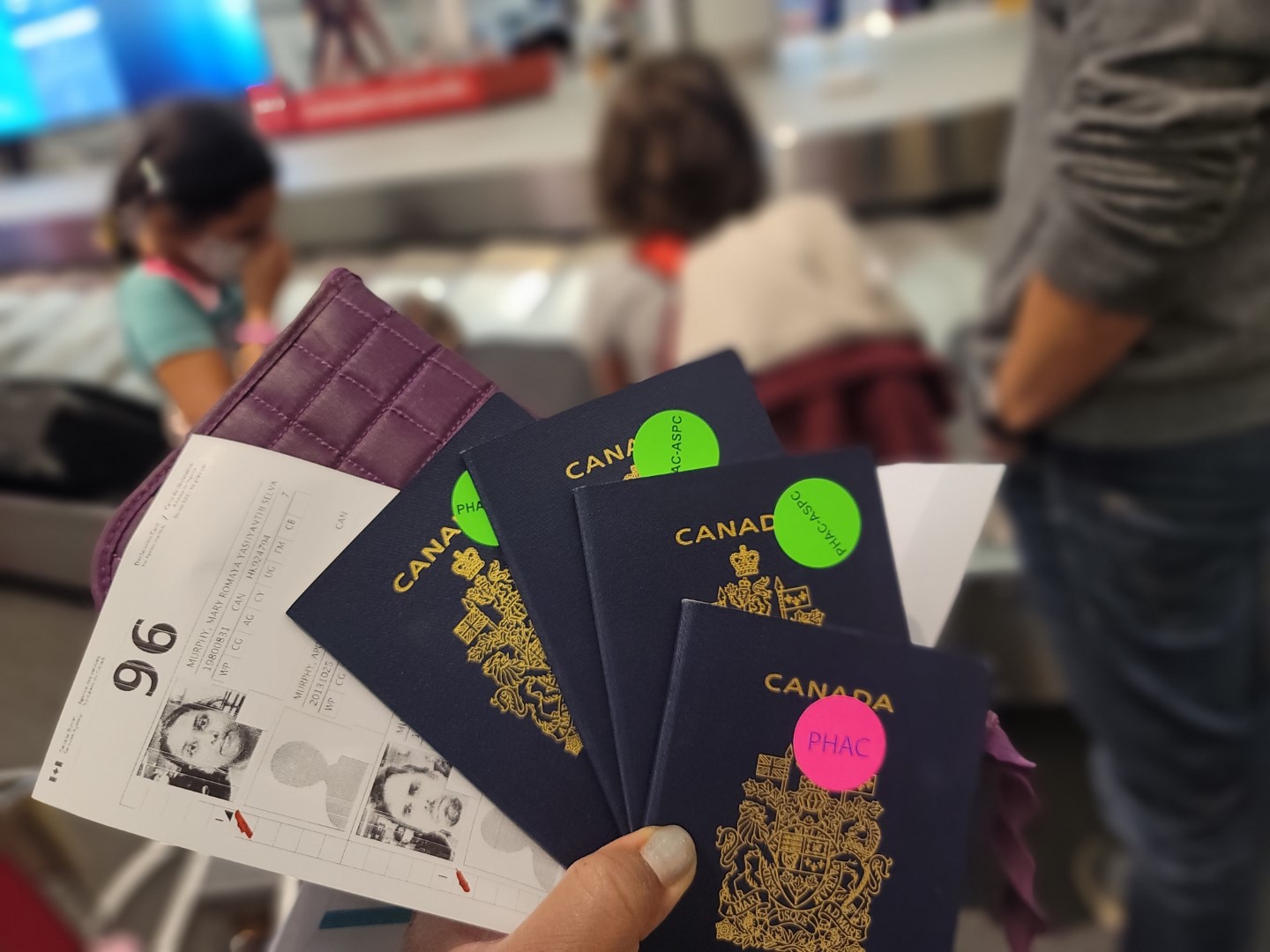 passports with pink and green stickers at Pearson
