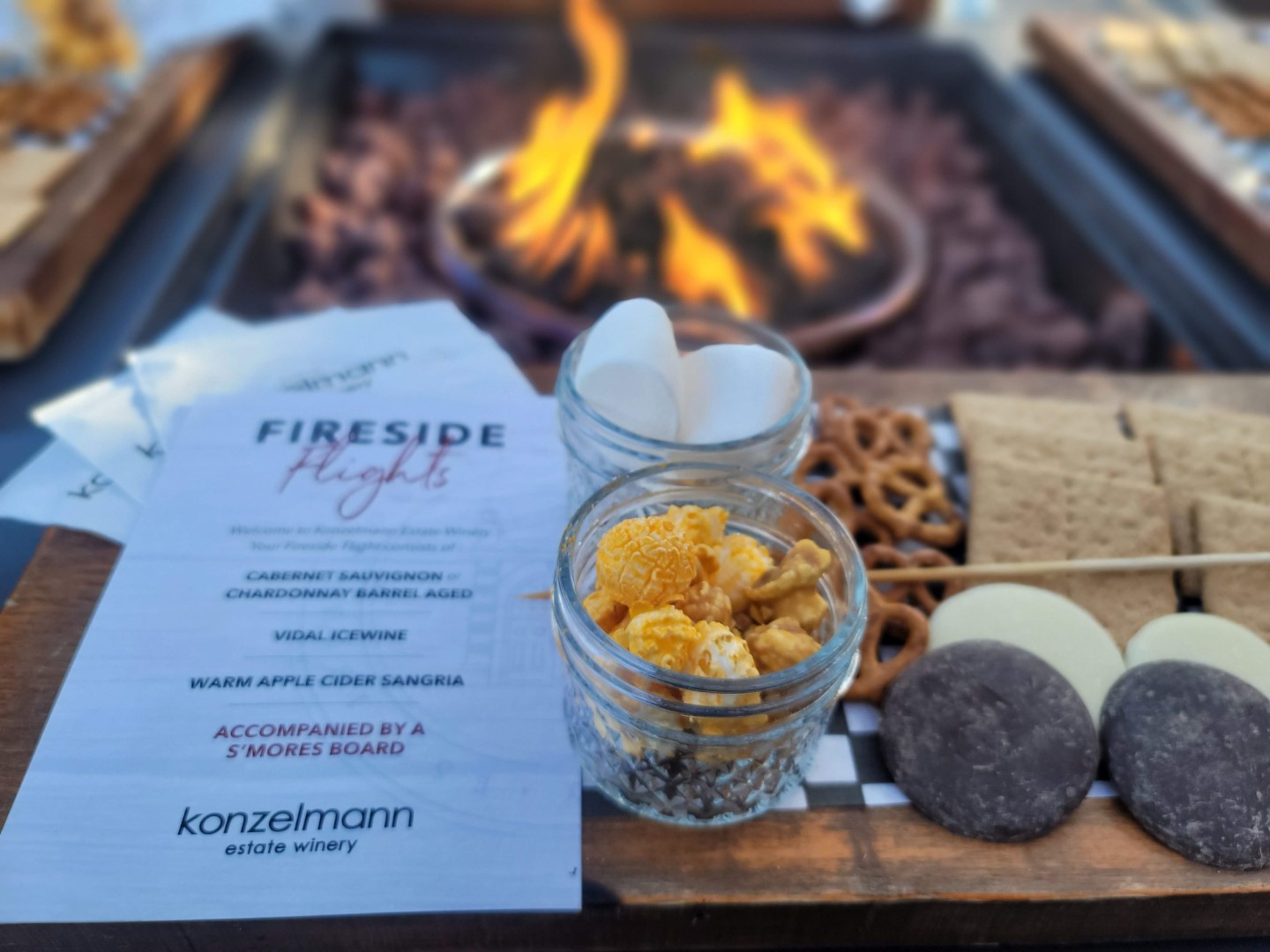 wine tasting flight with popcorn and smores next to fire pit