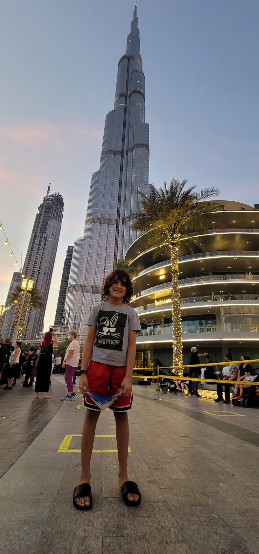 Boy with mask in hand Outside Dubai Mal