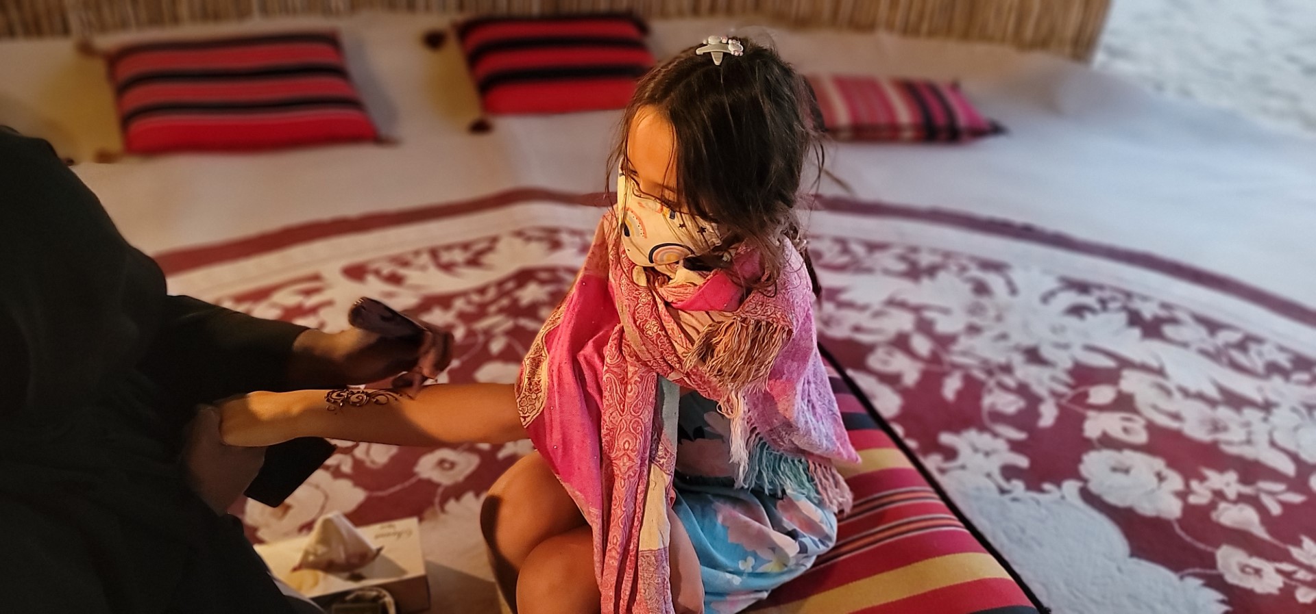 henna on masked girl wrapped in shawl