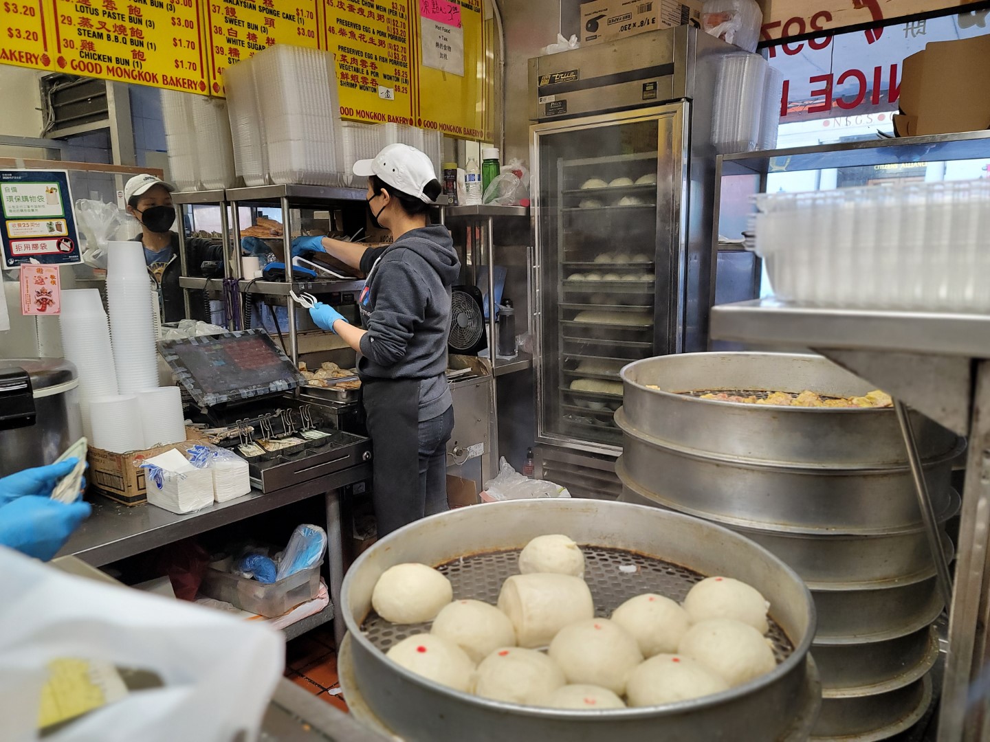 person cooking dumplings and buns in Chinatown restaurant