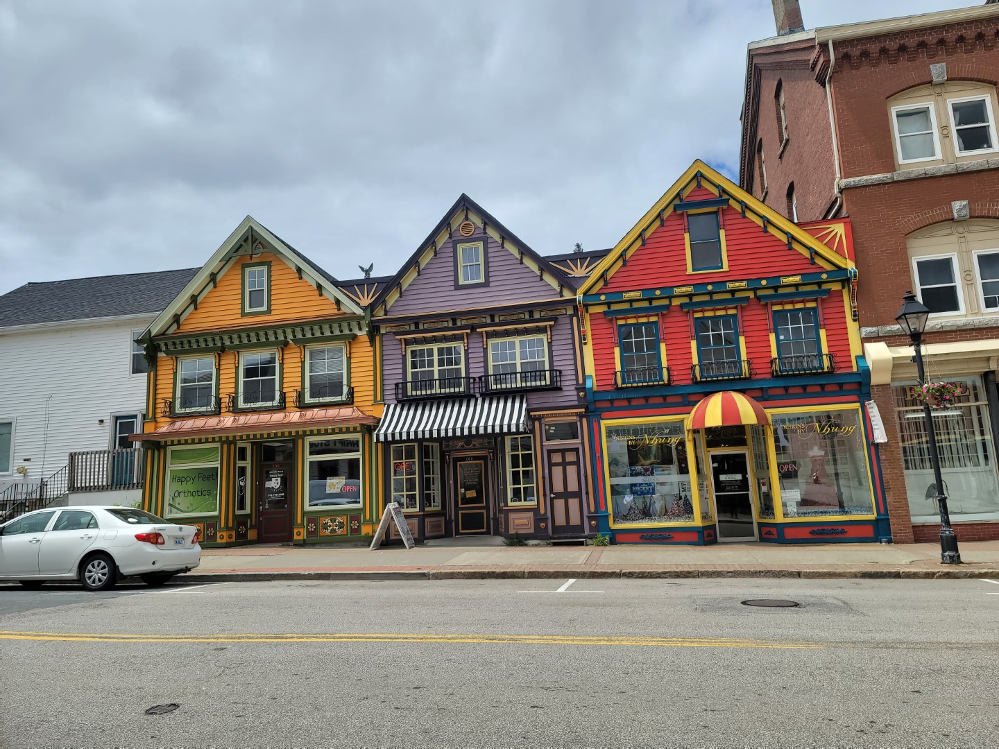 colourful stores in Yarmouth Nova Scotia with white car on road