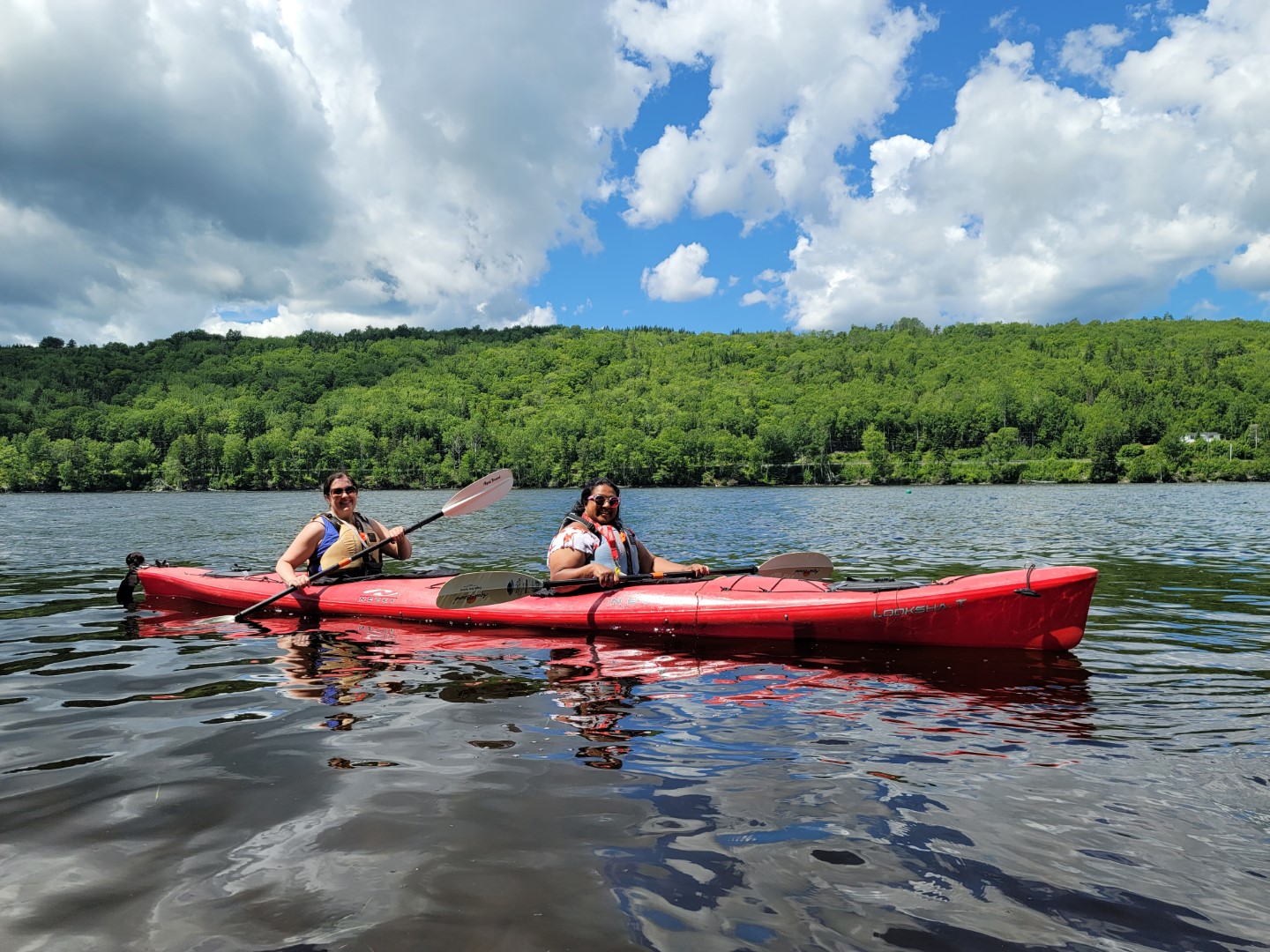 Ladies kayaking in Cape Breton on a clear day with clouds