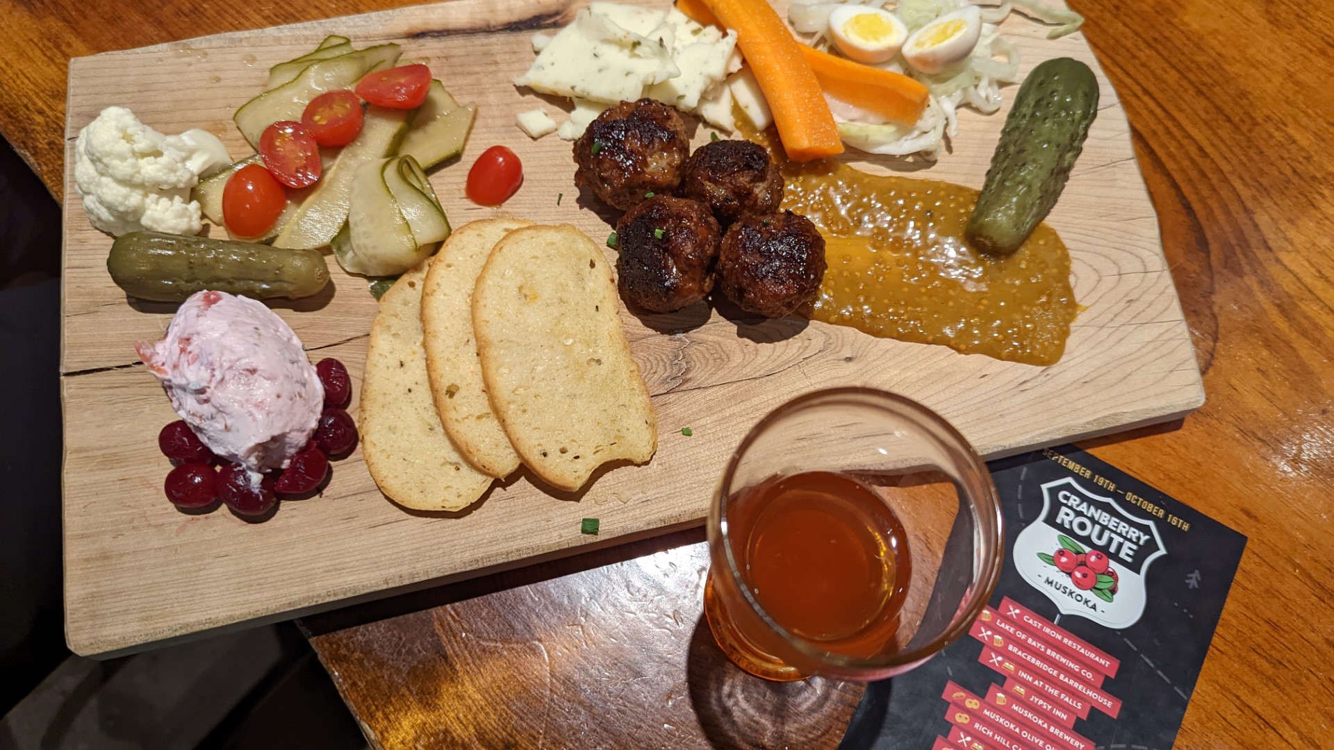 meet and cheese board with cranberry route map and beer