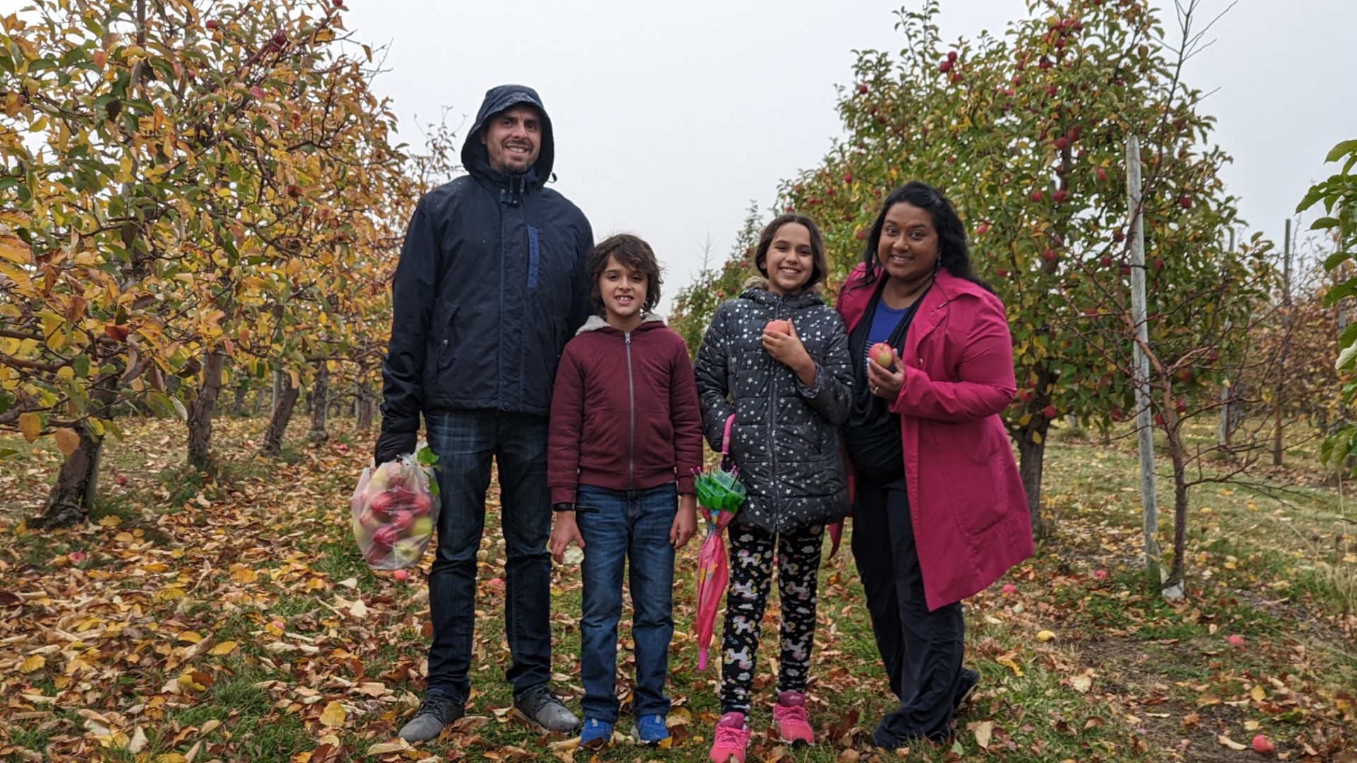 Murphy family standing in an Ontario apple orchard