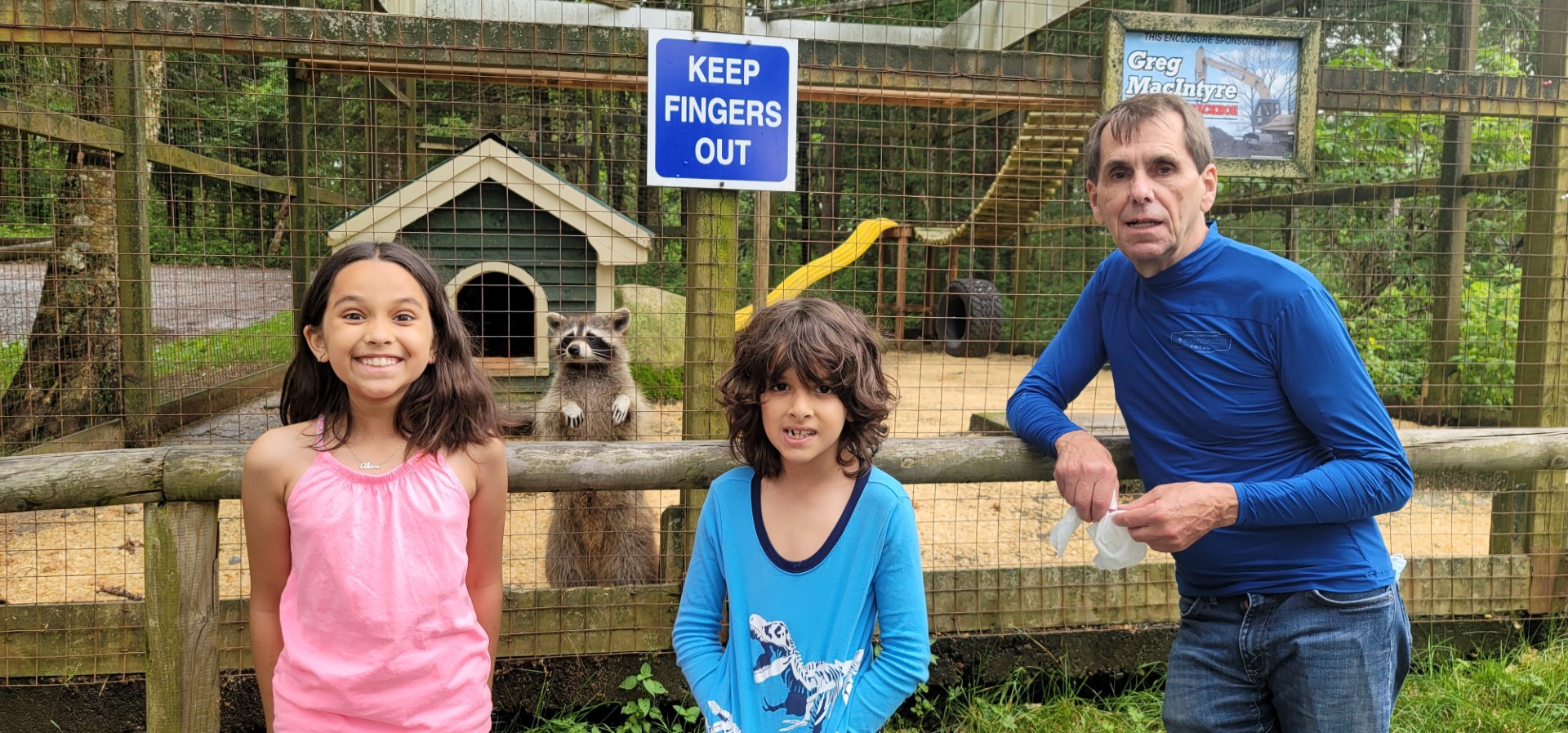 family with racoon at Two River's Wildlife Park Nova Scotia