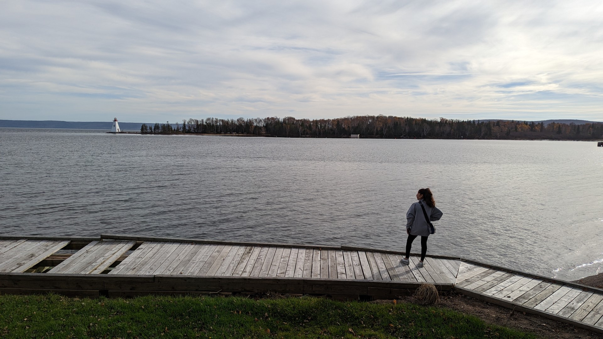 Person looking out at Kidston Lighthouse in BAddeck