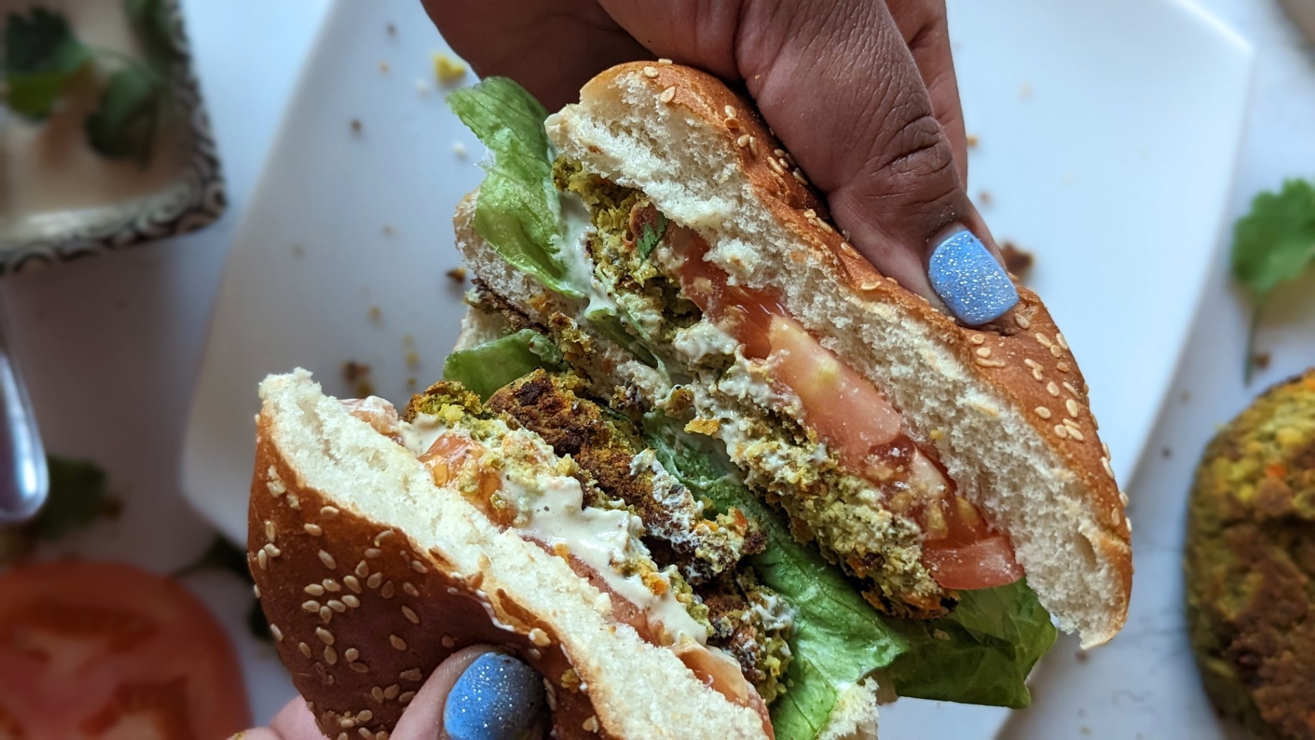 Falafel burger with toppings in hand