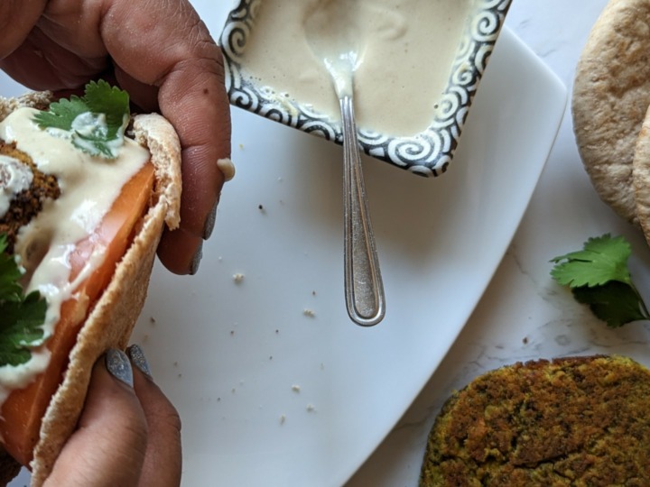 hands holding falafel burger in pita
