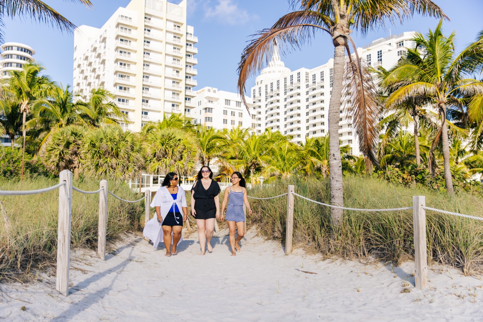 ladies walking on beach in front of Loews Miami Beach Hotel