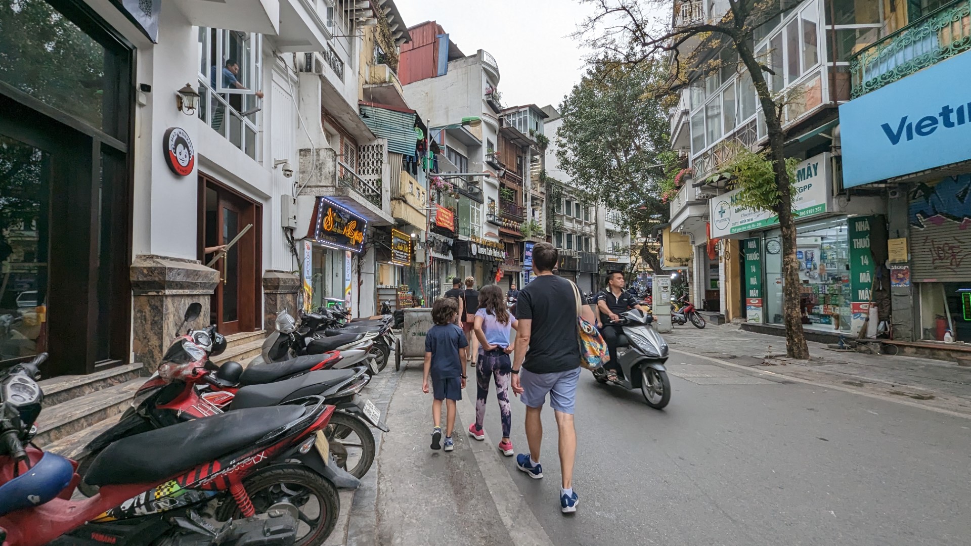 kids and dad walking the streets of hanoi