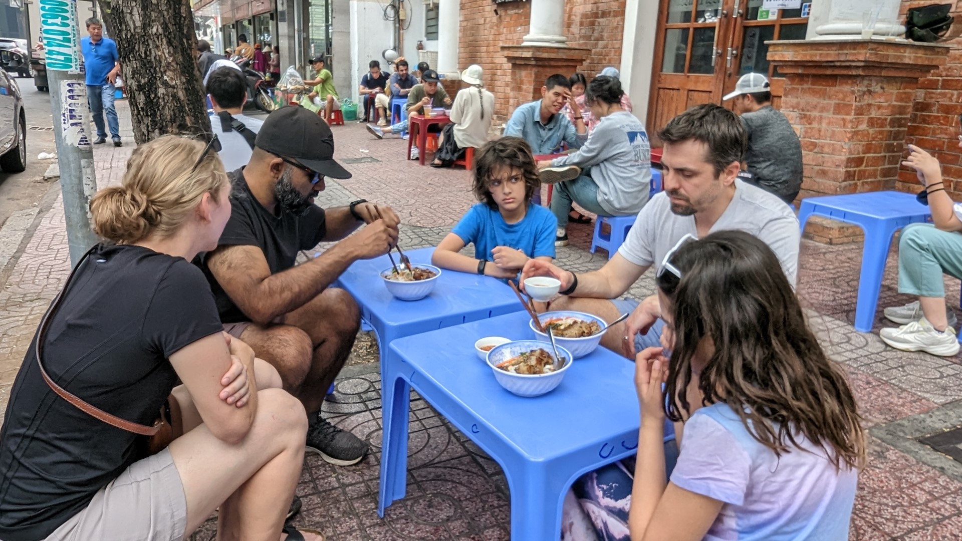 family eating in Vietnam at road side 