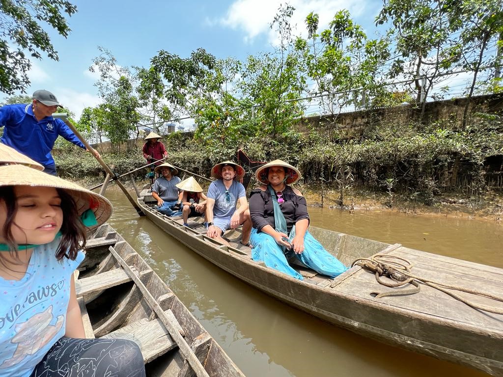 Family on sampan row boat in Mekong Delta