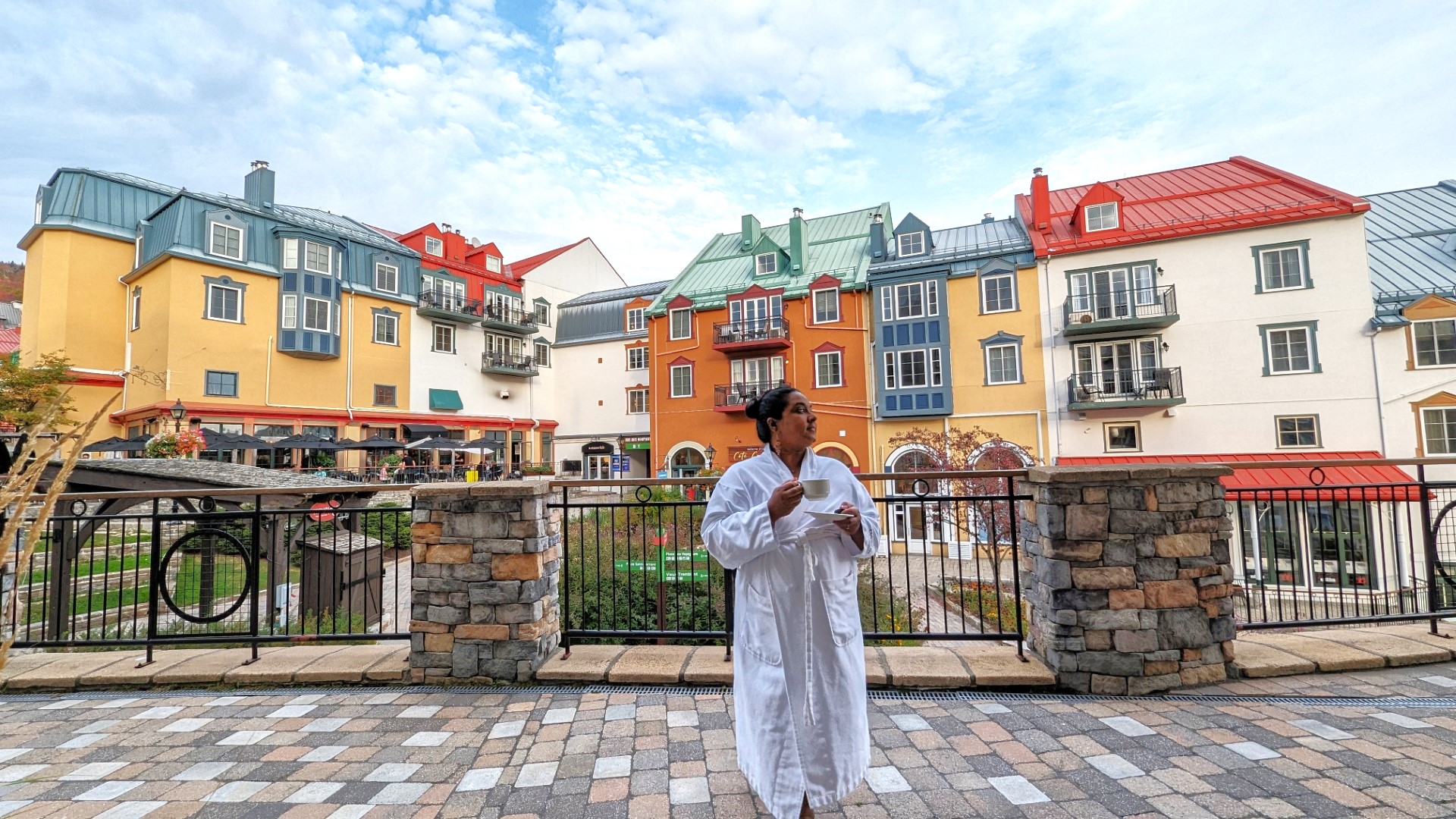 lady holding cup in bathrobe with Tremblant village in the background