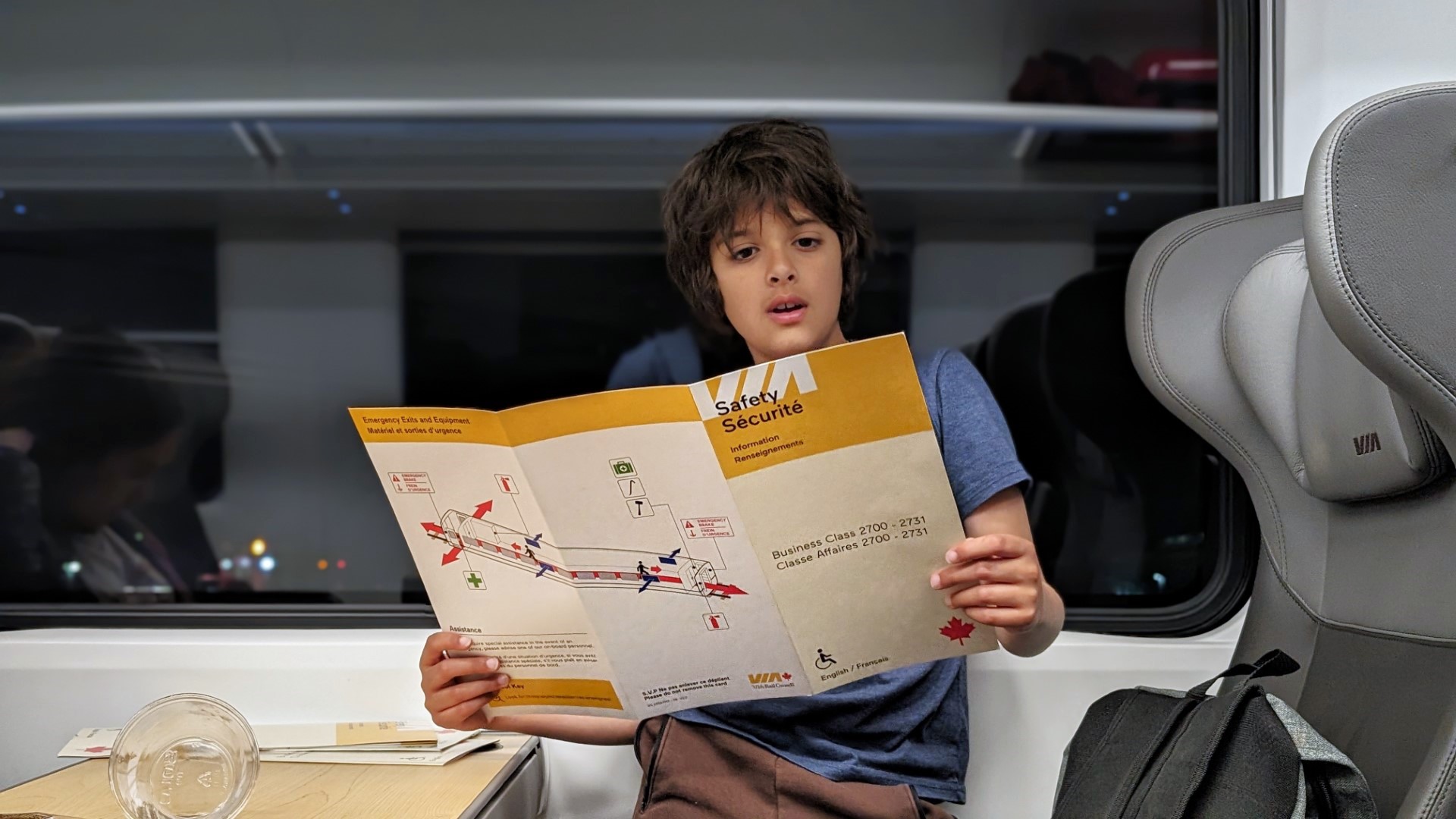 Boy holding VIA Rail safety manual