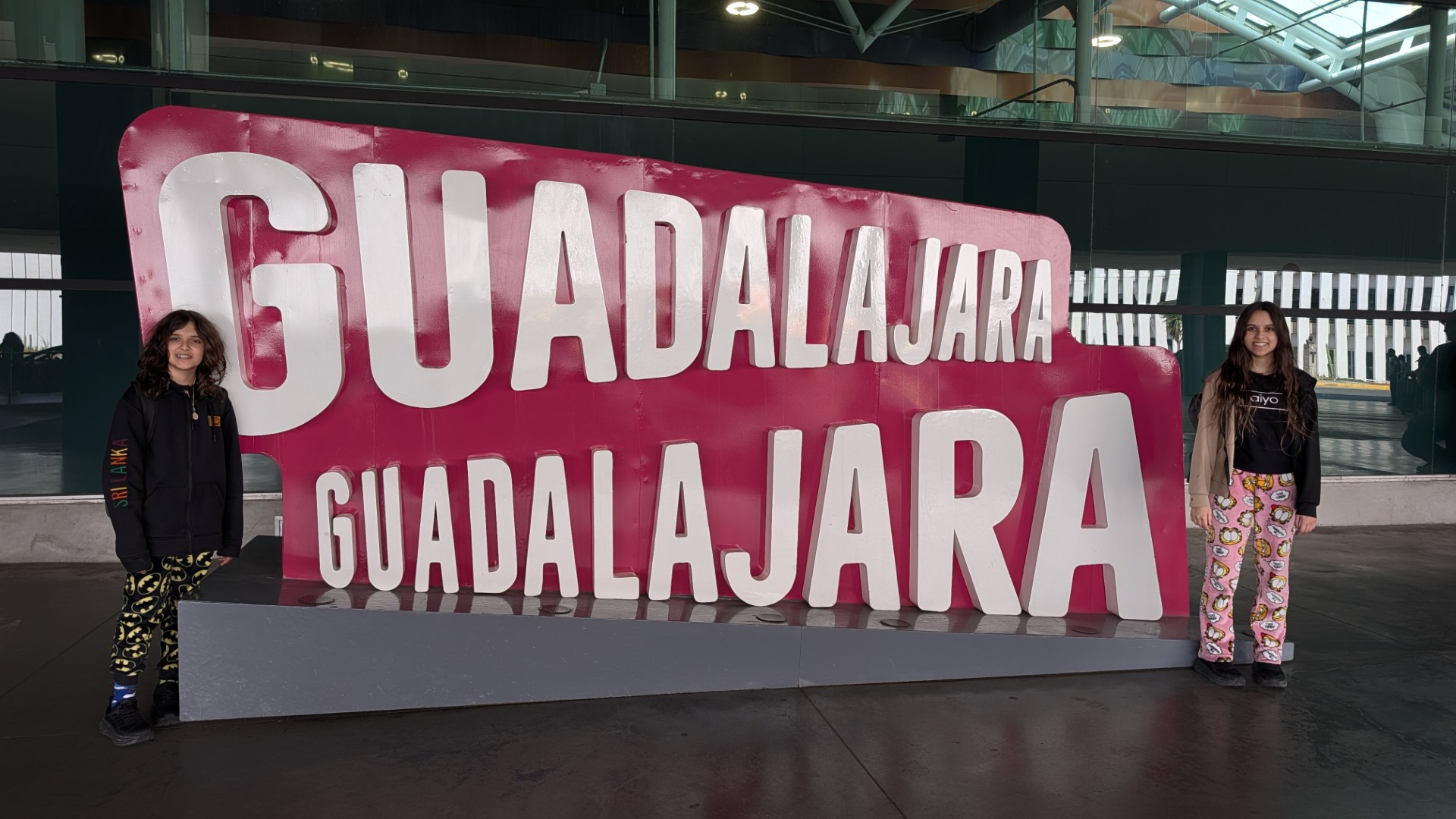 kids in front of Guadalajara airport sign